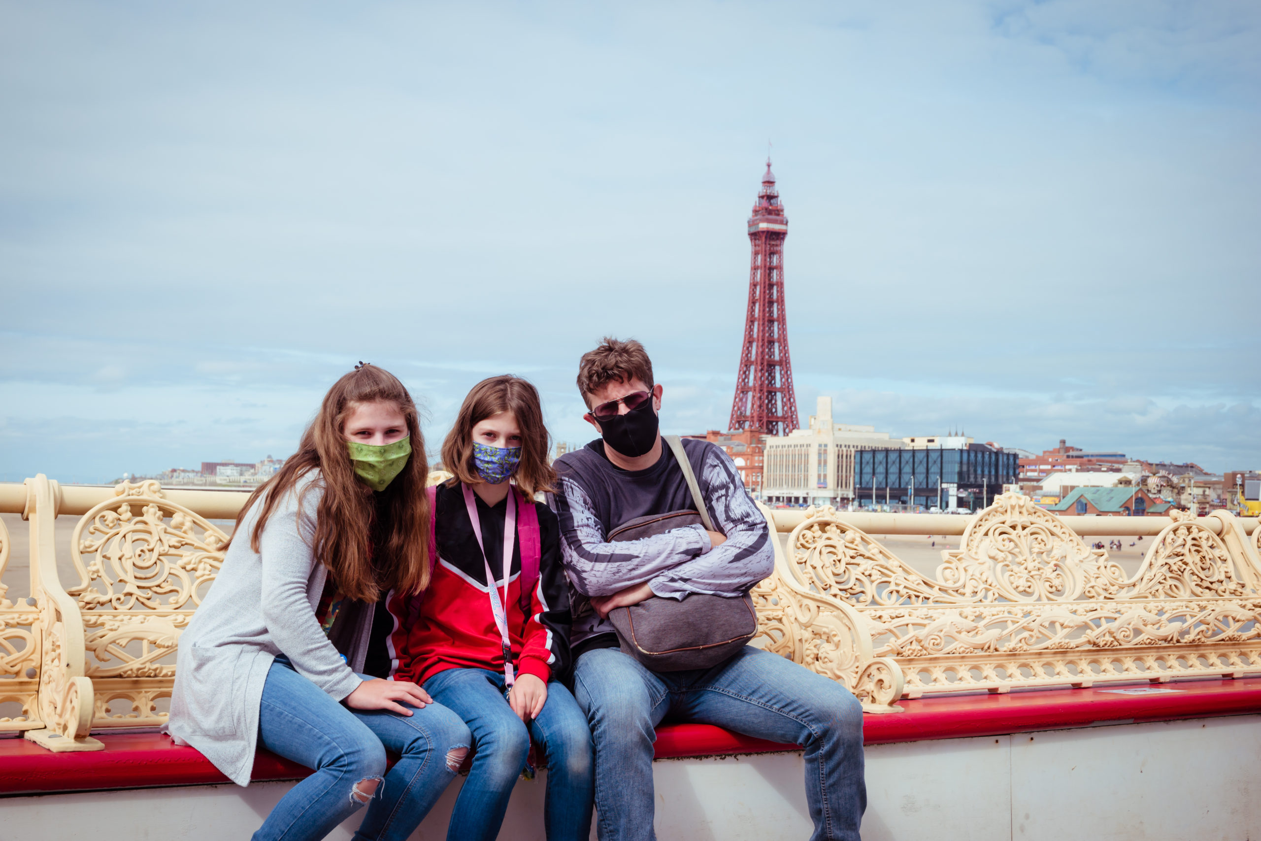 family together at seaside siting with next of kin and face masks